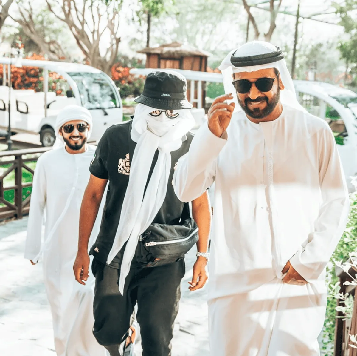 Kekra masqué en tenue blanche, entouré de deux hommes
