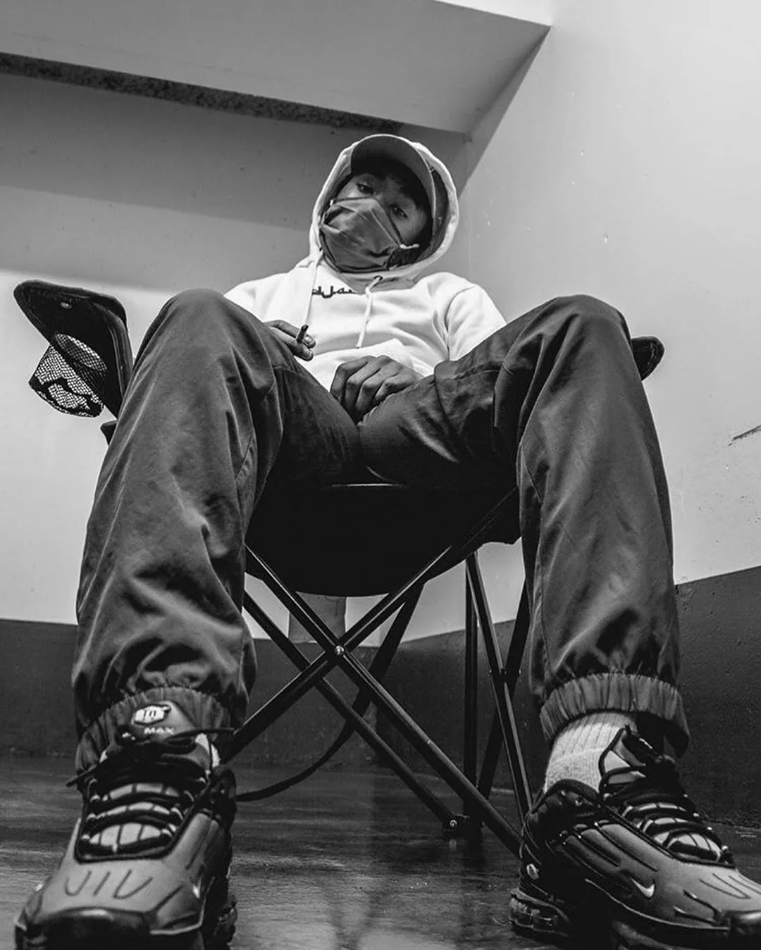 D4R assis sur une chaise pliante, en noir et blanc
